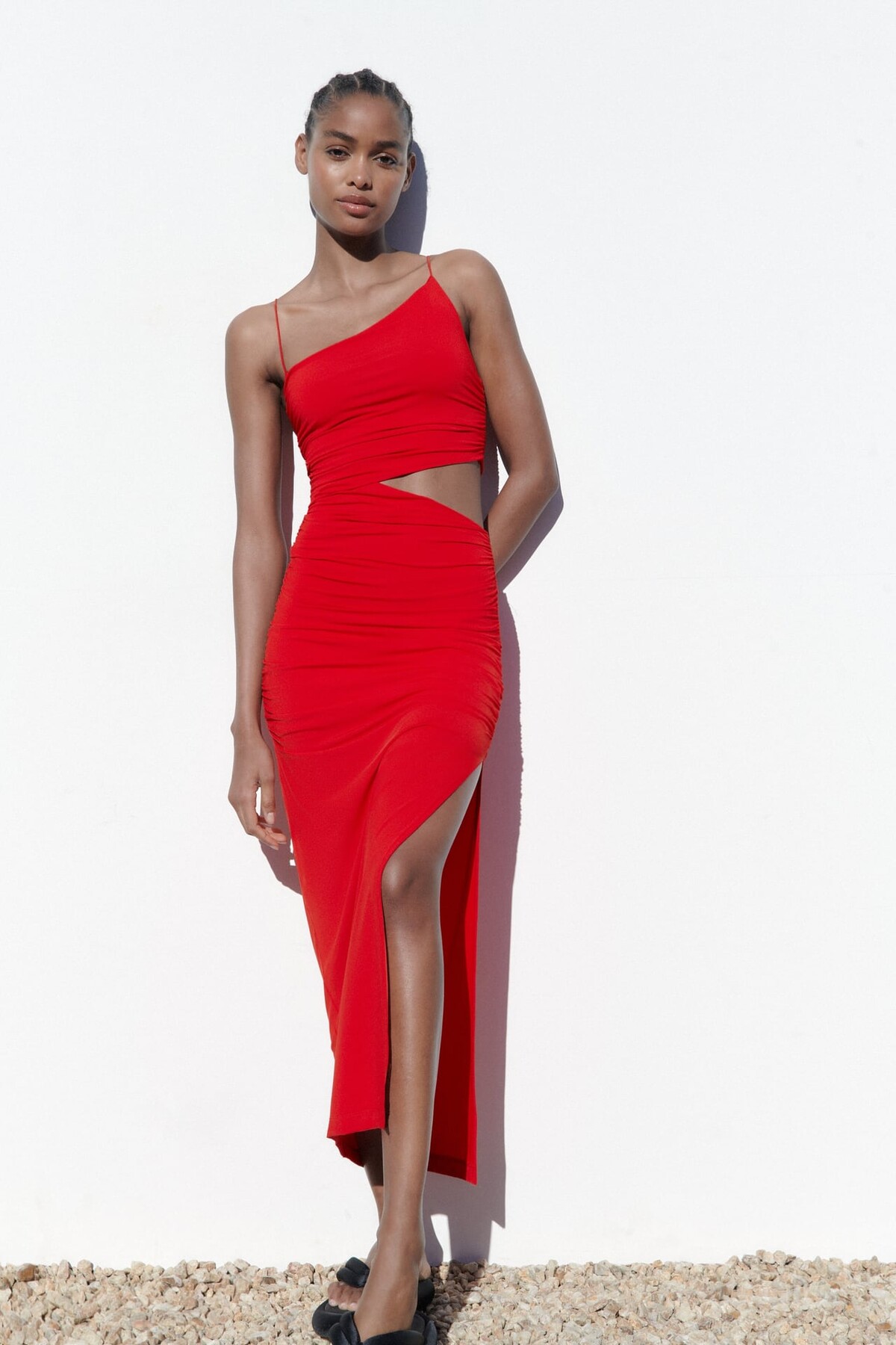 Asymetrické a elastické šaty v sexi červenej a s výrazným výstrihom v oblasti pásu môžeš mať od Zary už za 22,95 eura.