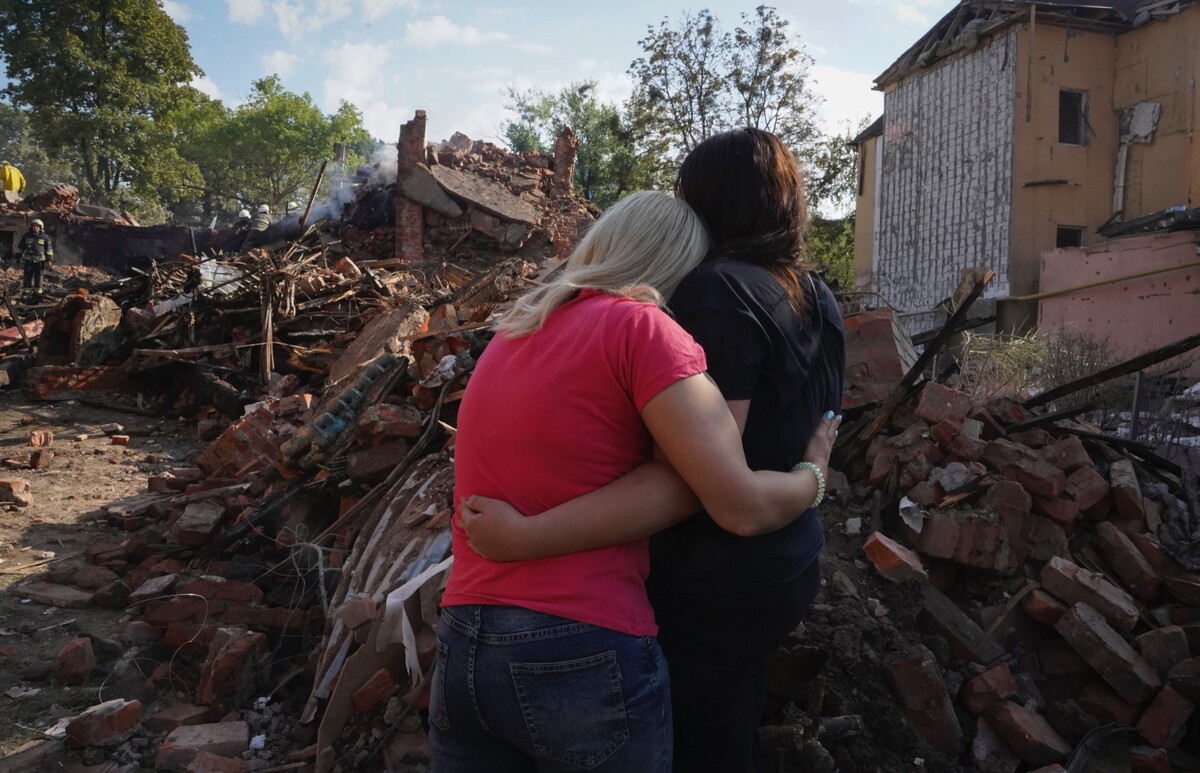 Ukrajinské ženy sa objímajú pred budovou zničenou pri raketovom útoku v druhom najväčšom ukrajinskokm meste Charkov počas 178. dňa ruskej invázie na Ukrajinu.(18. augusta 2022)