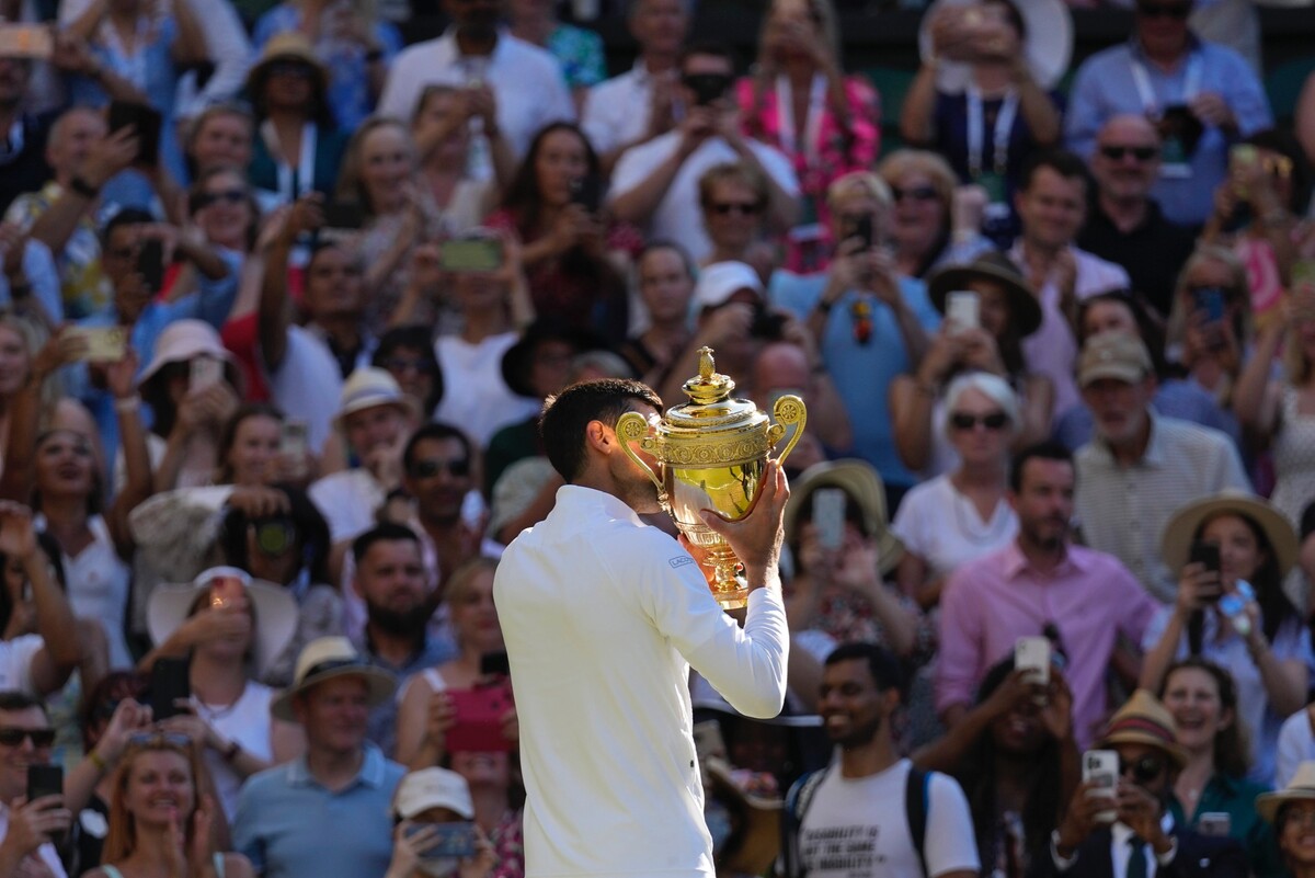 Srbský tenista Novak Djoković bozkáva trofej víťaza prestížneho grandslamového turnaja vo Wimbledone po tom, ako v Londýne porazil Austrálčana Nicka Kyrgiosa. Pripísal si tak na konto 21. grandslamové víťazstvo. (10. júla 2022)