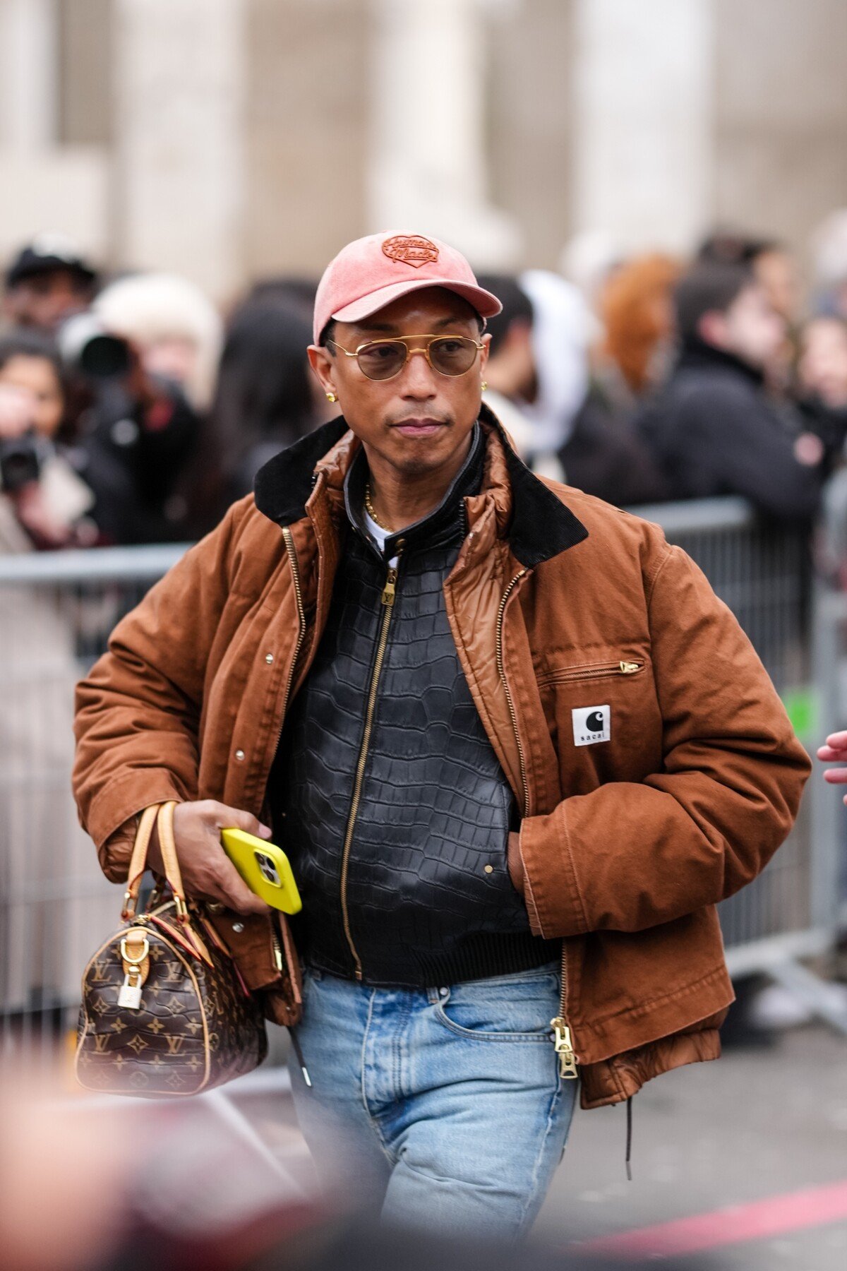 Pharrell Williams v hnedom modeli utility jacket zo spoločnej kolekcie značiek Sacai a Carhartt WIP.