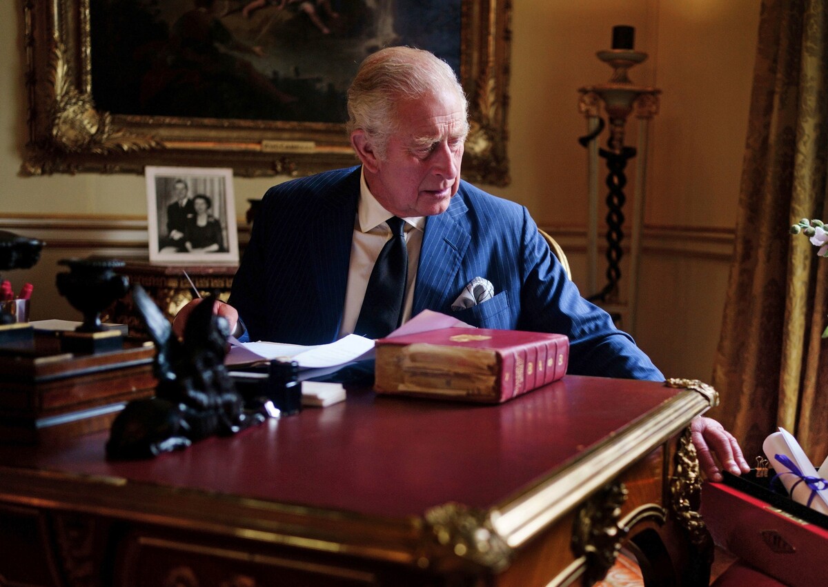 Prvý záber Karola III. pri plnení kráľovských povinností. Na snímke sedí za pracovným stolom a vyberá z oficiálnej červenej krabice korešpondenciu, ktorú mu pripravil osobný tajomník v miestnosti z 18. storočia v Buckinghamskom paláci. (24. septembra 2022)
