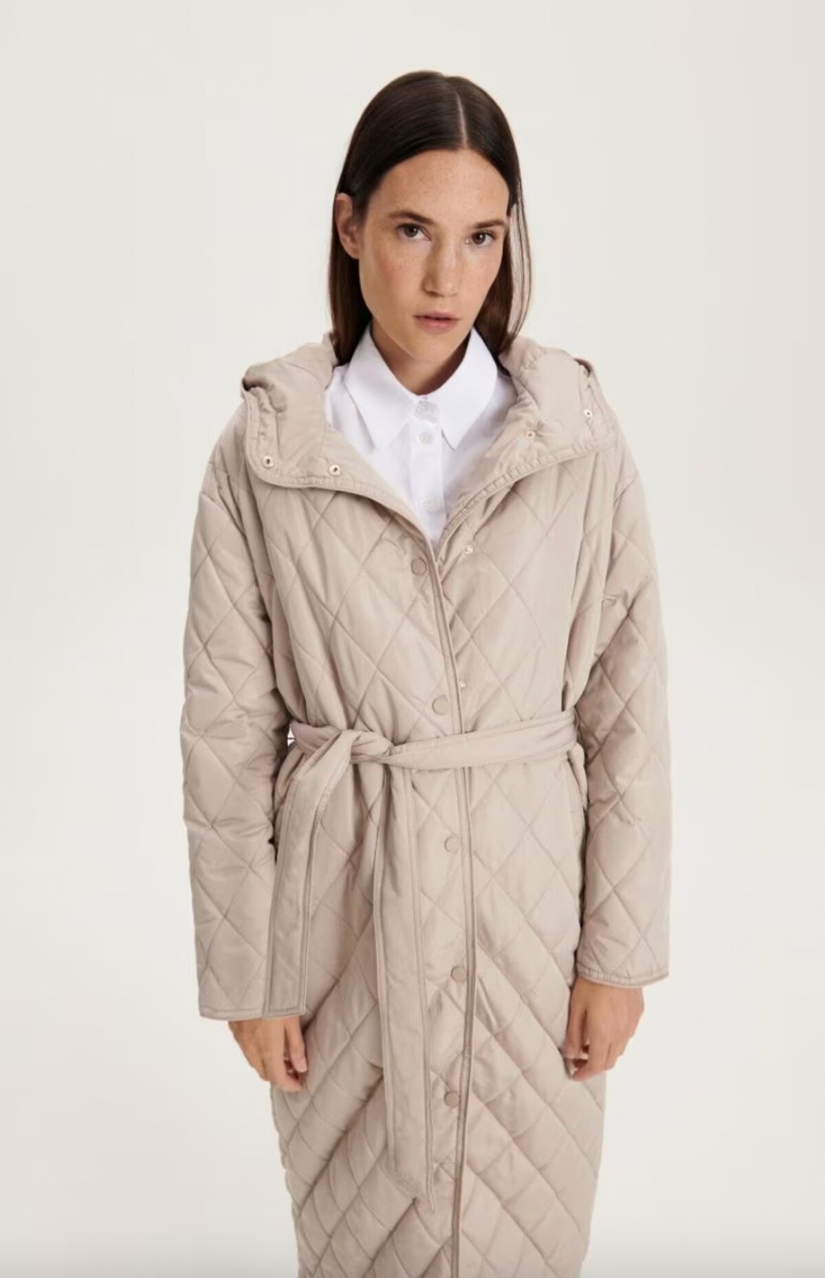 Béžový prešívaný kabát so zaväzovacím opaskom nájdeš za 49,99 eura v ponuke značky Reserved.