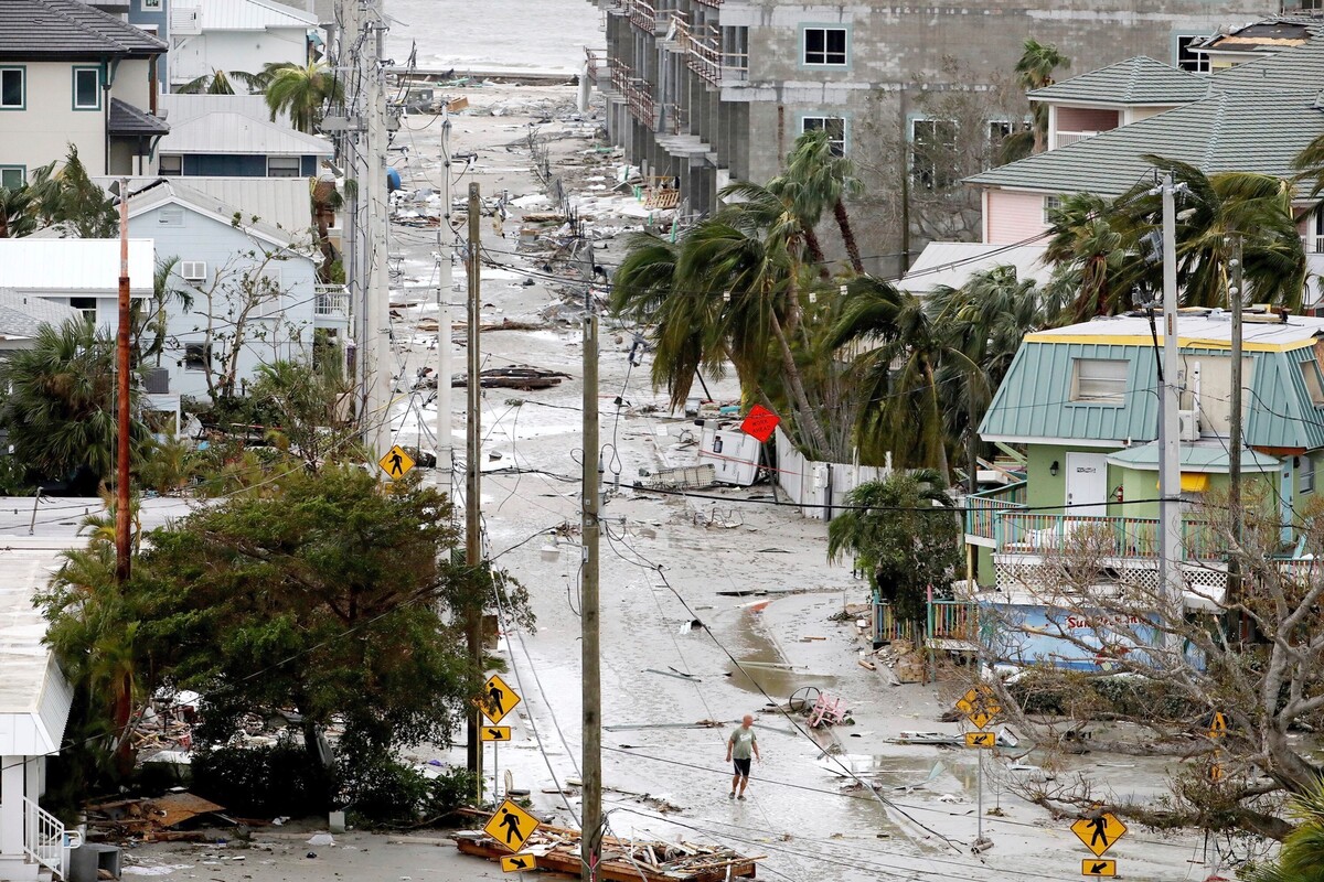 Muž kráča cez ulicu posiatu troskami zo zničených domov a obchodov v meste Fort Myers na Floride po tom, ako sa oblasťou prehnal hurikán Ian. Extrémne nebezpečný hurikán zasiahol v stredu pobrežie amerického štátu Florida a priniesol silný vietor a hustý lejak. (29. septembra 2022)