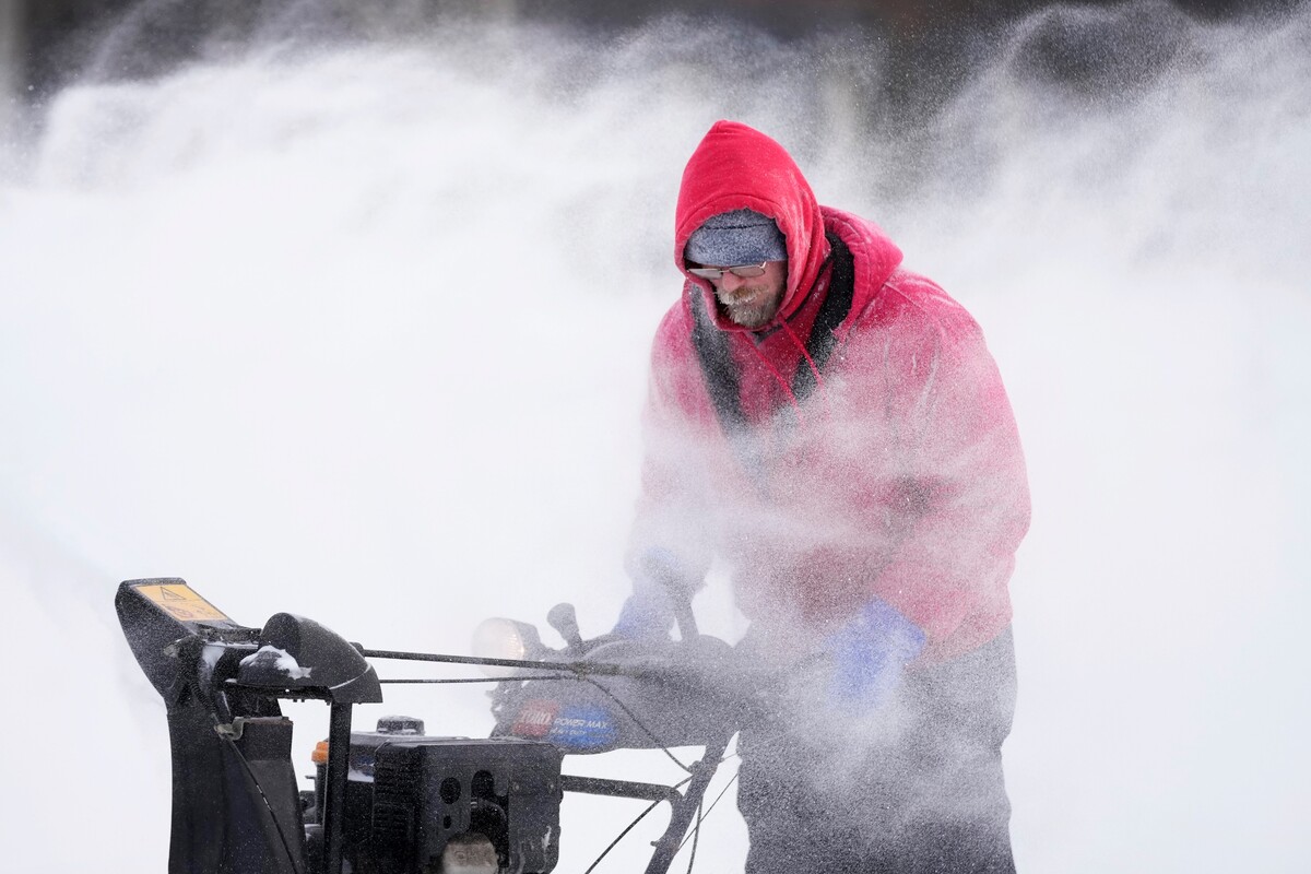Mark Sorter odstraňuje sneh z klziska v centre mesta Des Moines v americkom štáte Iowa v piatok 23. decembra 2022.