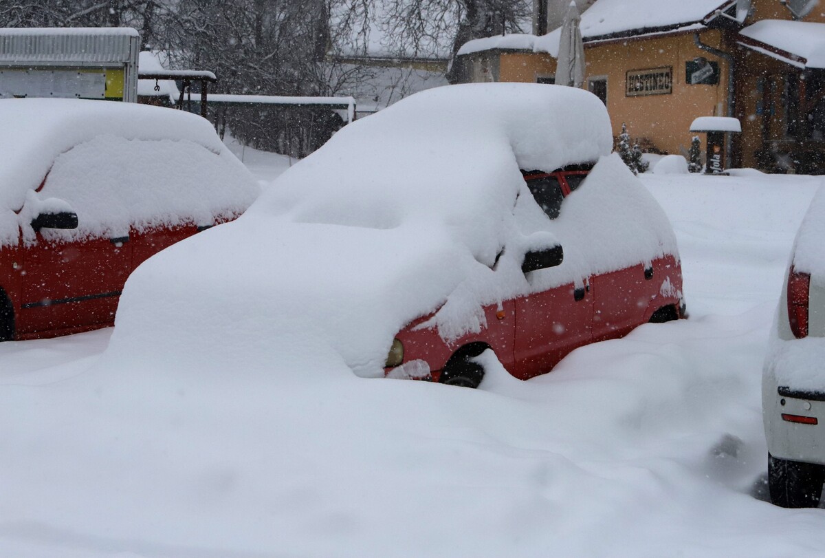 Zapadnuté auto počas sneženia v Starých Horách pri Banskej Bystrici 3. februára 2023.
