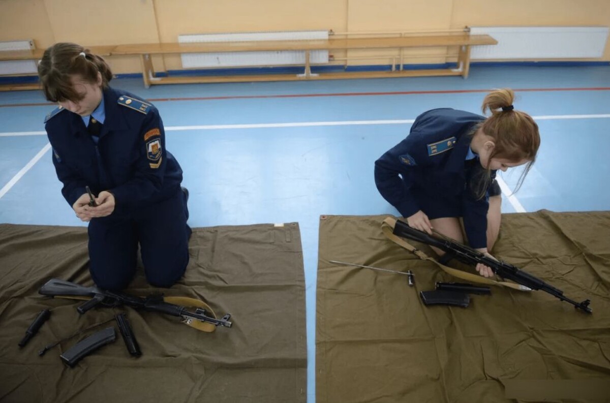 Dievčatá v uniformách sa učia rozoberať samopal.