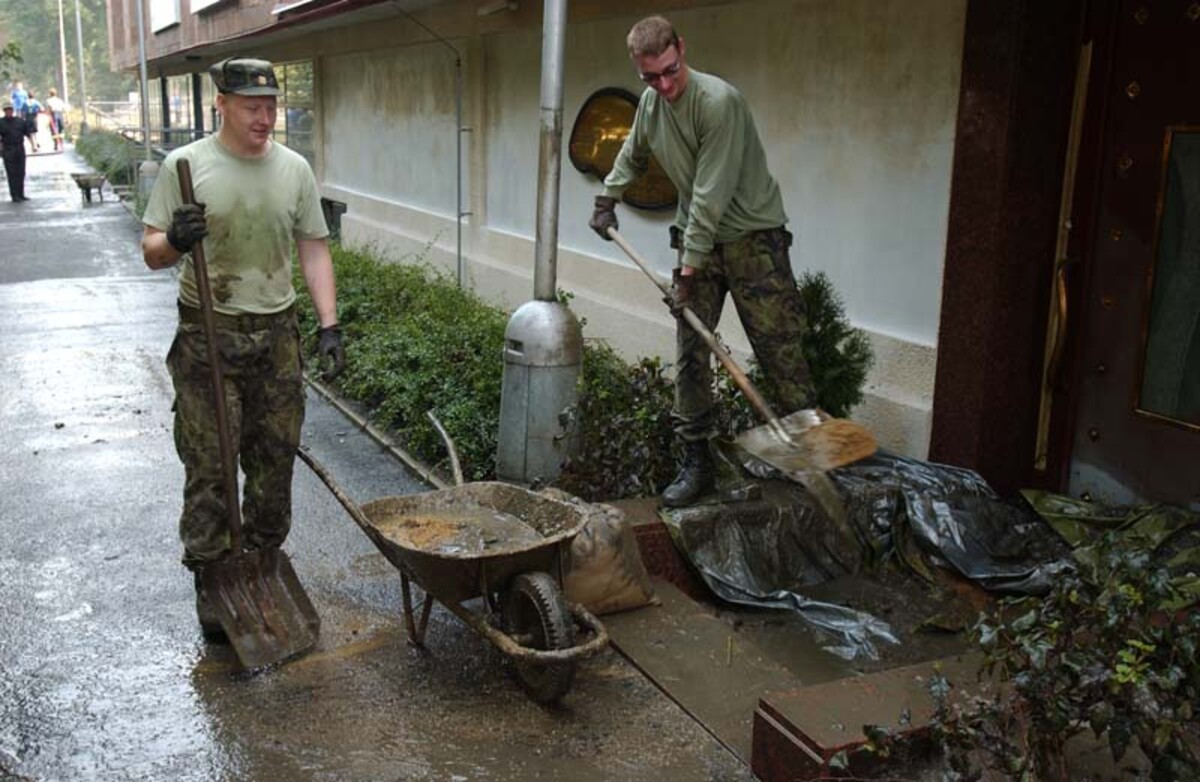 Vojáci pomáhají uklízet následky povodní.