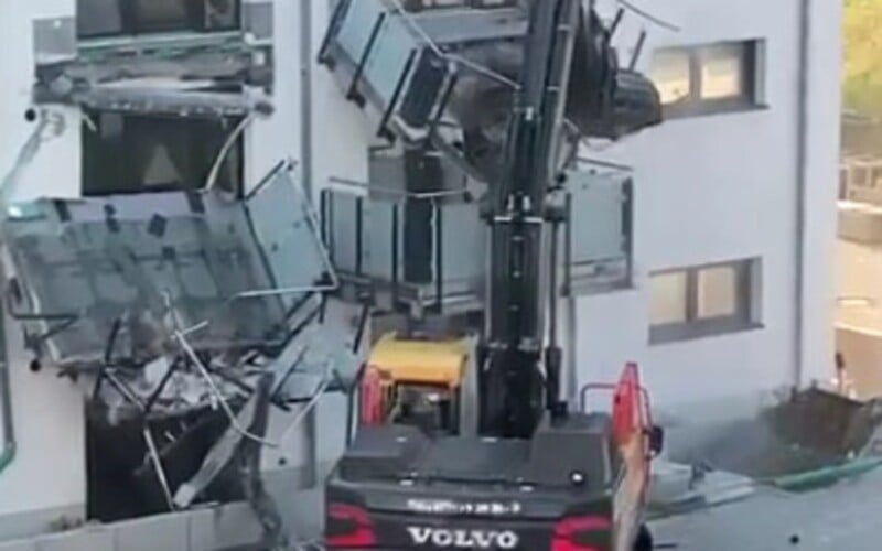 VIDEO: Bagrista se rozzuřil a strhl dva balkony z bytového domu. Rozzlobilo ho, že nedostal řádně zaplaceno.