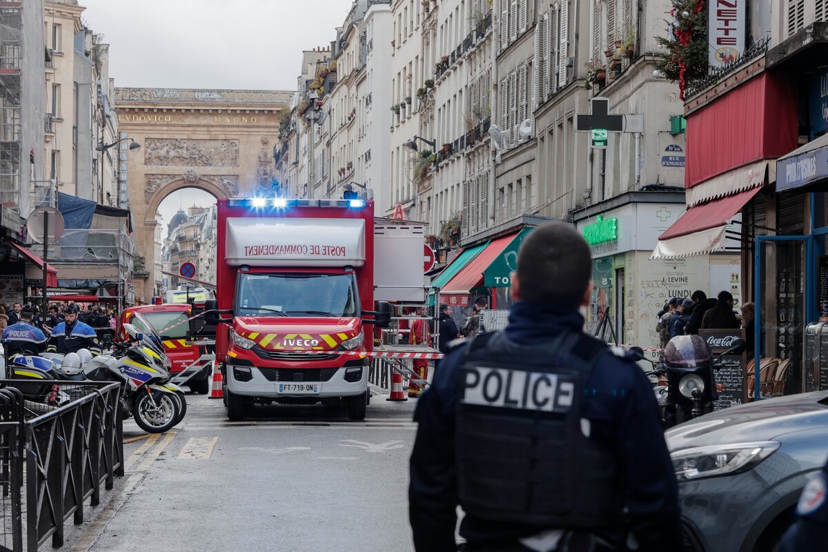 Policajt stojí pri mieste, ktoré uzatvorila polícia po streľbe v centre Paríža v piatok 23. decembra 2022.