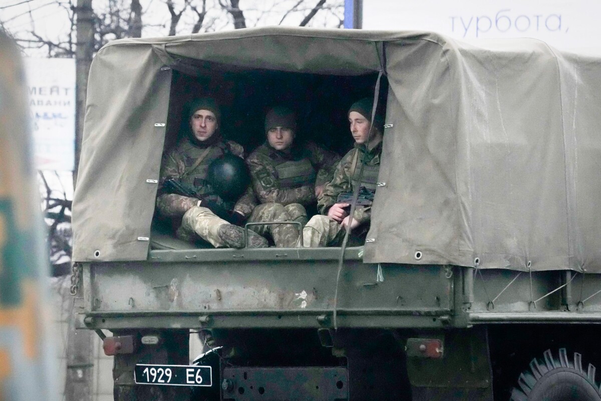 Ukrajinskí vojaci sedia vo vojenskom vozidle v meste Mariupol v Doneckej oblasti na juhovýchode Ukrajiny vo štvrtok 24. februára 2022.