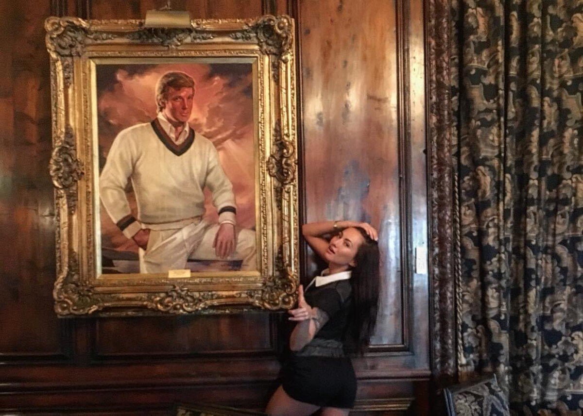 Michaela Isizzu v Mar-A-Laga, svojho času dom Donalda Trumpa, pózujúca s jeho obrazom.