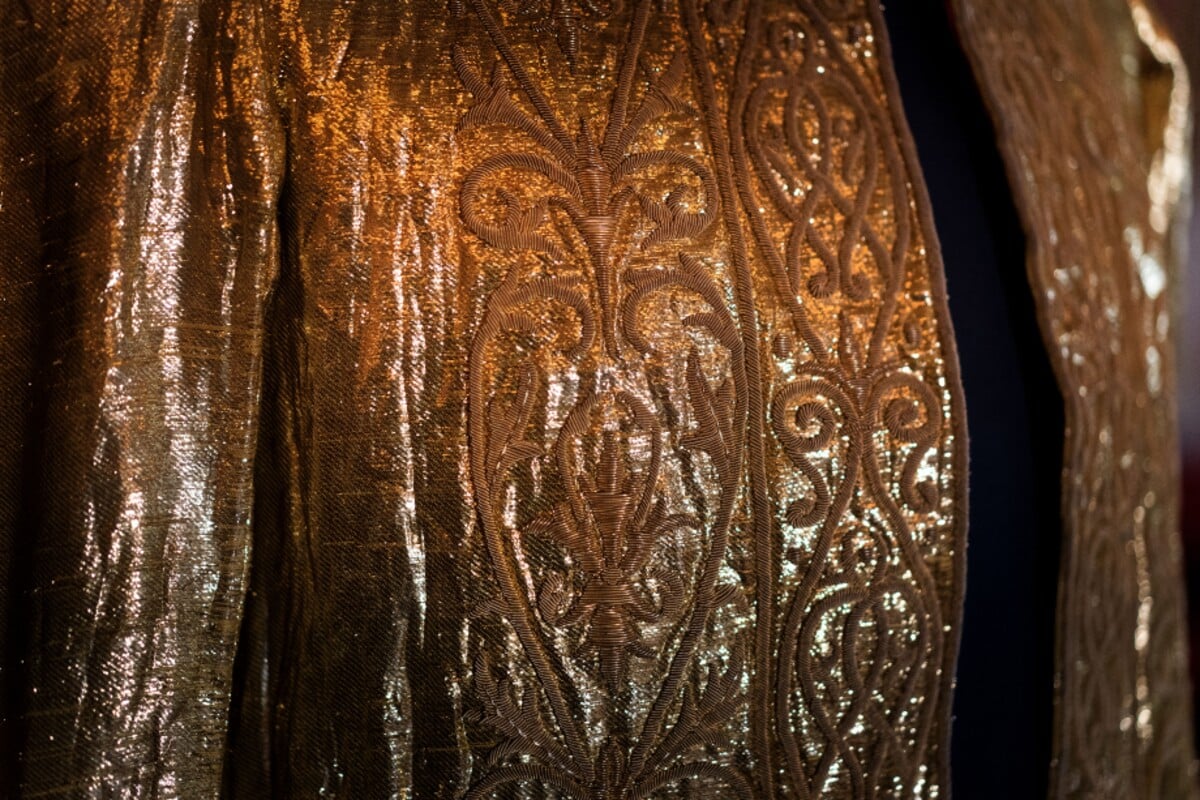 Detail vrchní zlaté tuniky.