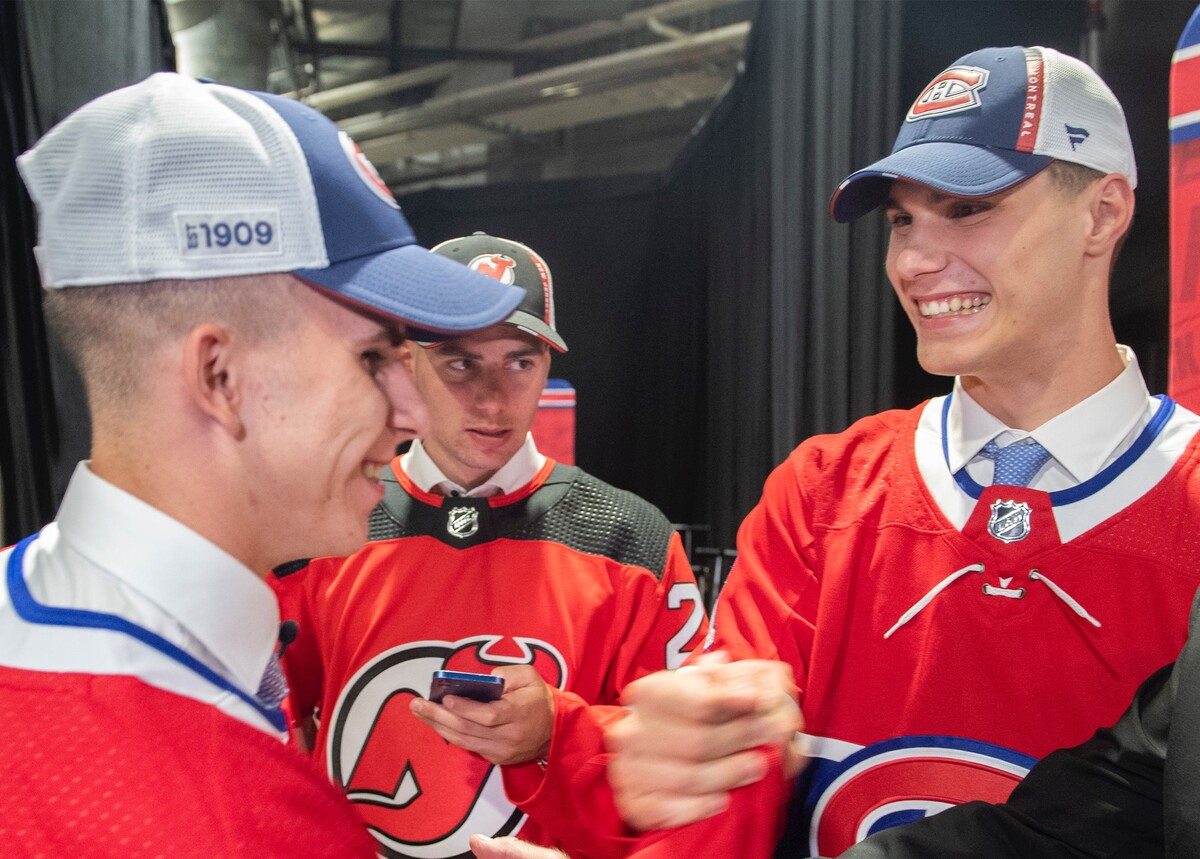 Slovenskí hokejisti sprava Juraj Slafkovský (Montreal Canadiens), Šimon Nemec (New Jersey Devils) a Filip Mešár (Montreal Canadiens) sa tešia počas prvého kola draftu zámorskej hokejovej NHL v Montreale 7. júla 2022.