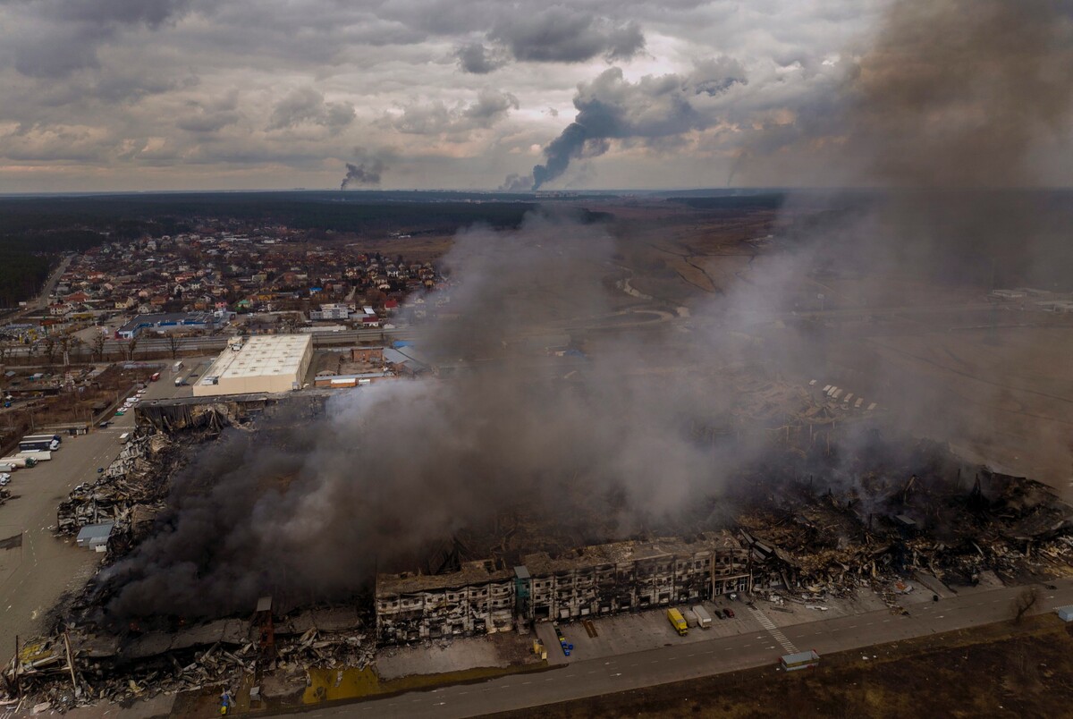 Na snímke horiace budovy fabriky a obchodu po bombardovaní v meste Irpiň na predmestí Kyjeva v nedeľu 6. marca 2022.