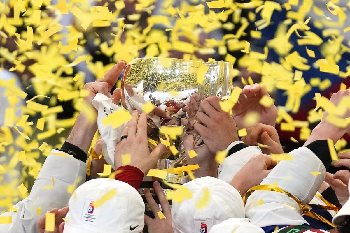 Čeští hokejisté zvedají trofej nad hlavu po výhře ve finálovém zápase.