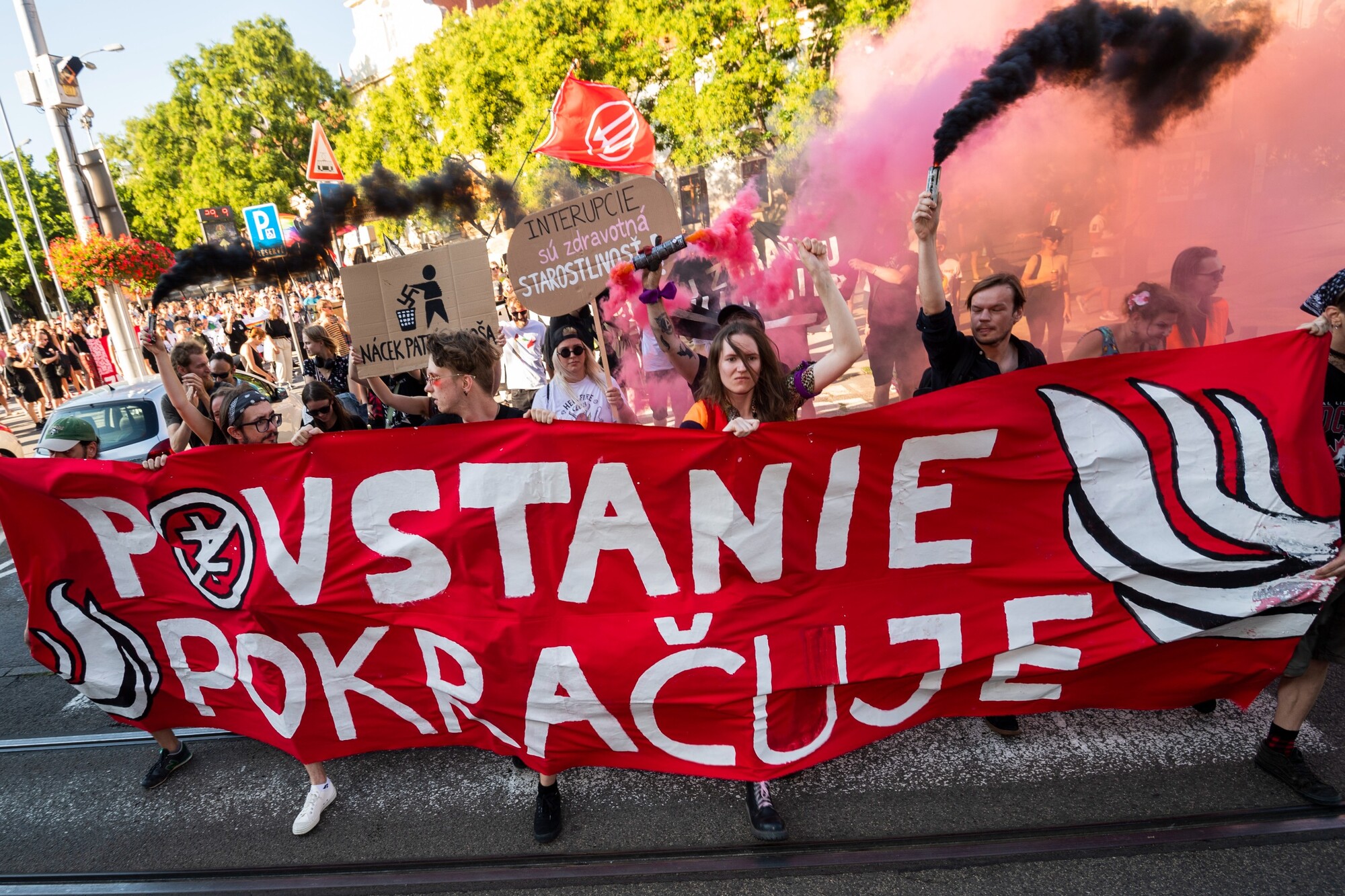 Ľudia držia transparent s nápisom Povstanie pokračuje na antifašistickom pochode pri príležitosti 78. výročia Slovenského národného povstania v Bratislave. (29. august 2022)