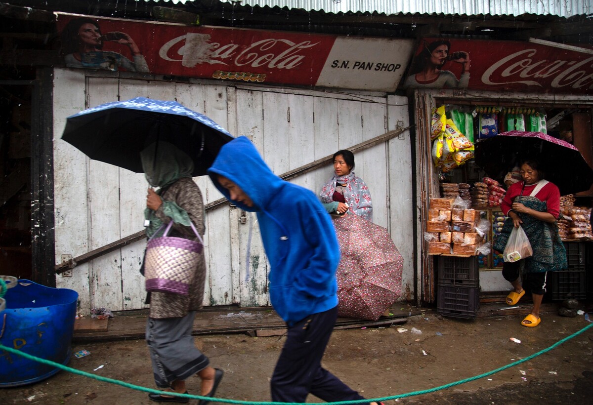 V indickém městě Kohima ve státě Nágáland kráčejí lidé po ulicích s deštníky. Během povodní v tomto státě zemřelo podle agentury TASR nejméně 8 lidí.