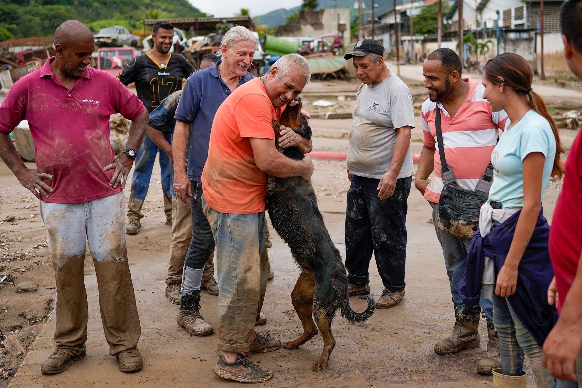 Muž objíma svojho psa, ktorého zachránili z bahna susedia počas záplav a zosuvu pôdy v meste Las Tejerías na severe Venezuely. (9. október 2022)