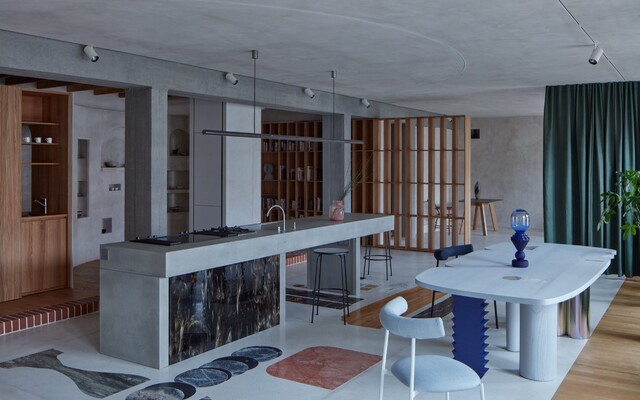 FOTO: Industriální byt v Praze se pyšní kuchyní, která vypadá jako jeskyně. Ukrývá také tajný vchod do knihovny