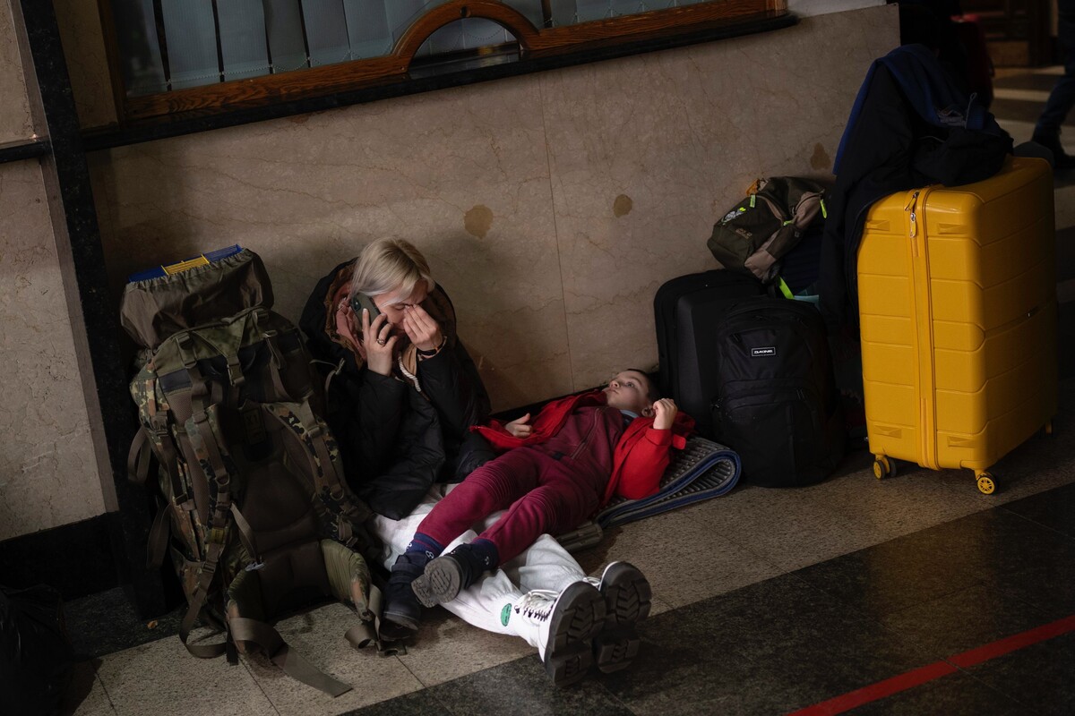 Žena a jej dieťa čakajú na vlak, keď opúšťajú Kyjev vo štvrtok 24. februára 2022.