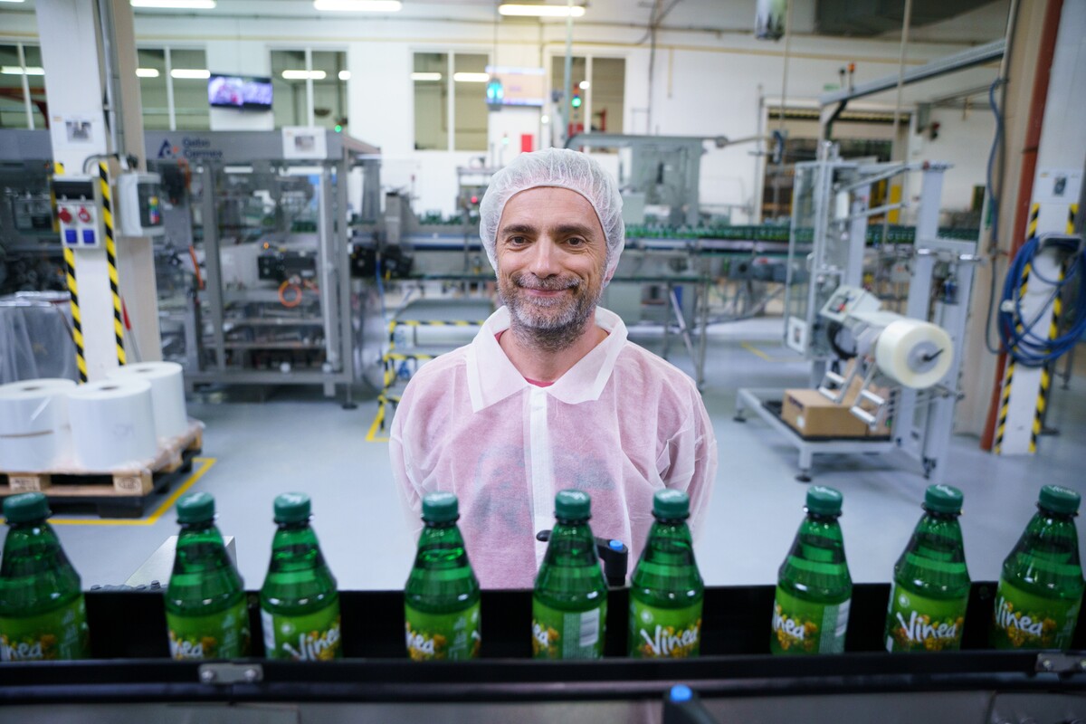 Jannis Samaras s naplnenými fľašami Viney. Aj tento tradičný nápoj vyrába skupina Kofola. 