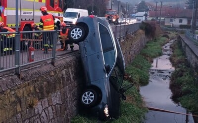 FOTO: Auto po nehodě viselo z mostu. Zranilo se šest lidí včetně několika dětí