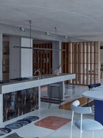 FOTO: Industriální byt v Praze se pyšní kuchyní, která vypadá jako jeskyně. Ukrývá také tajný vchod do knihovny