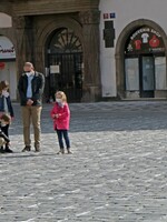 Na Staroměstské náměstí lidé nosí svíčky, fotografie a píší křídou jména zesnulých