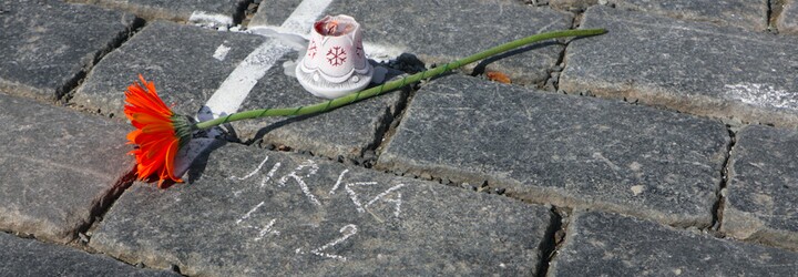 Na Staroměstské náměstí lidé nosí svíčky, fotografie a píší křídou jména zesnulých