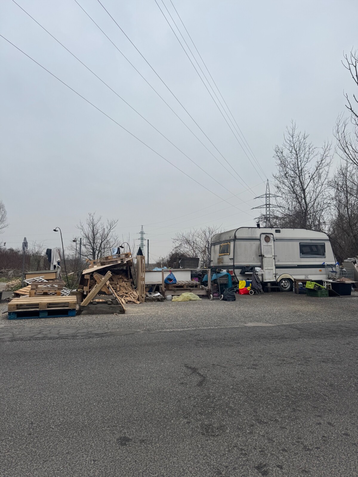 Okolo karavanu sú nahromadené rôzne veci. Najčastejšie palety, ktoré slúžia na kúrenie. Vedľa neho denne prejdú desiatky áut.