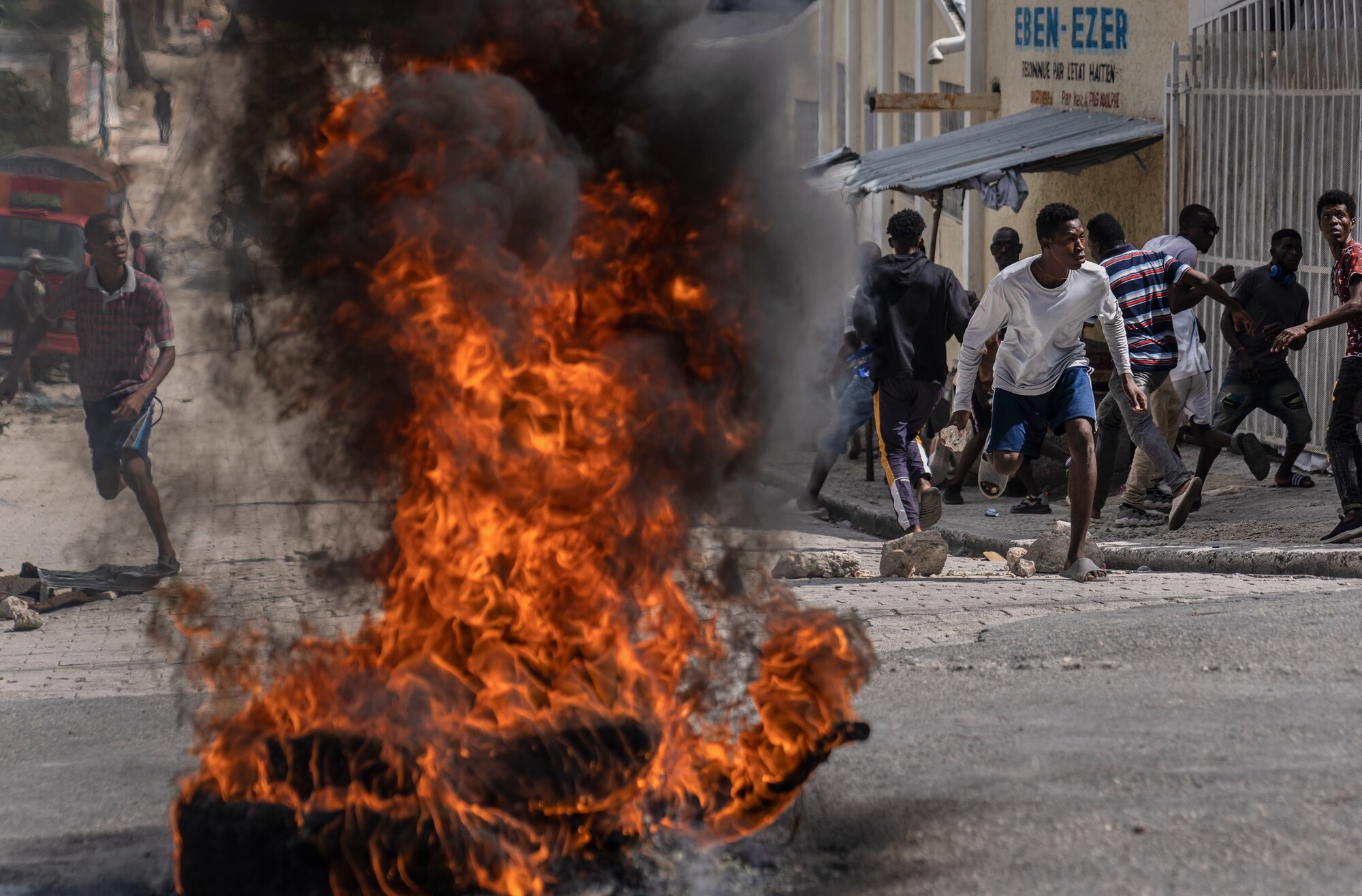 Demonštranti hádžu kamene do policajtov počas protestu, ktorý je reakciou na vraždu haitského novinára Romelsona Vilsainta. (30. októbra 2022)