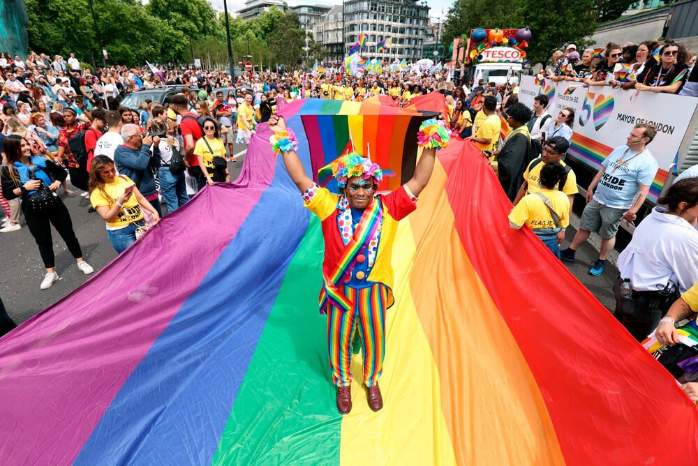 Mohammed Nazir z Londýna pózuje na velké duhové vlajce při příležitosti londýnského pochodu Pride, který se konal v sobotu 2. července. Zástupy oslavovaly 50. výročí hnutí Pride v Británii.