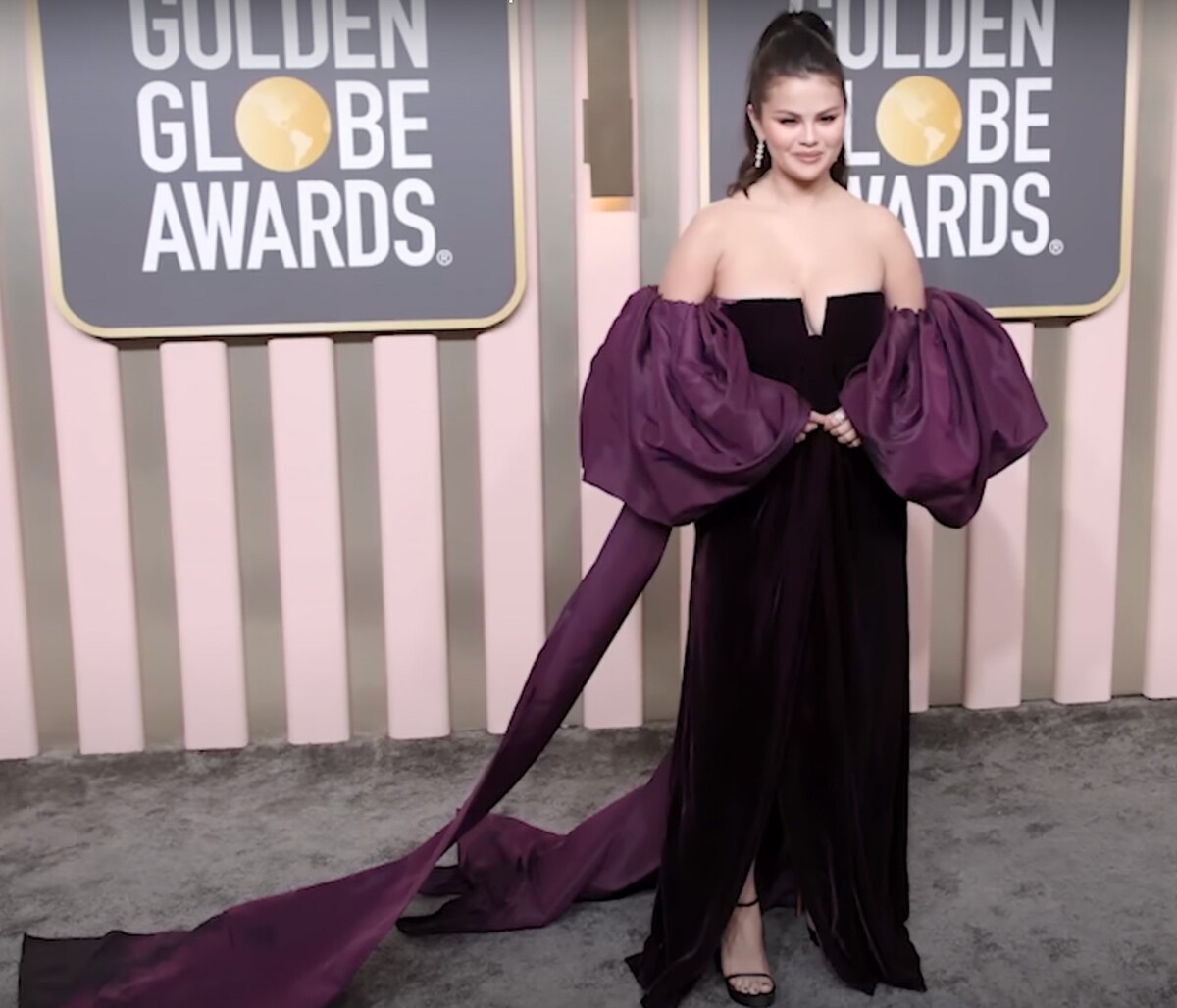 O outfit Seleny Gomez sa postarala značka Valentino. Sel žiarila v extravagantnej čiernej róbe s bordovými volánovými rukávmi, pričom zvolila jednoduchý mejkap, ktorý inšpirovali 90. roky.