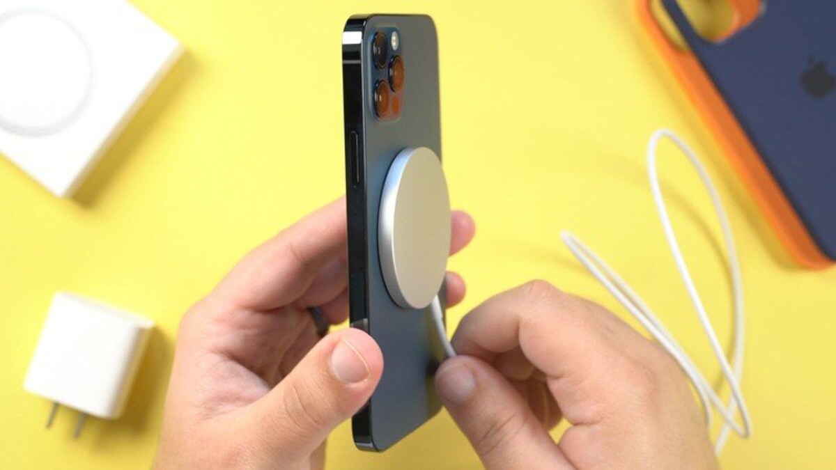Minuloročný iPhone 12 pripojený k nabíjačke pomocou MagSafe. Ilustračná fotografia.