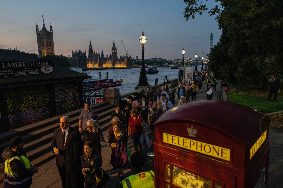 Ľudia, ktorí sa prišli naposledy rozlúčiť so zosnulou britskou kráľovnou Alžbetou II., stoja v rade vedúceho do sídla parlamentu Westminsterkého paláca v Londýne 14. septembra 2022.