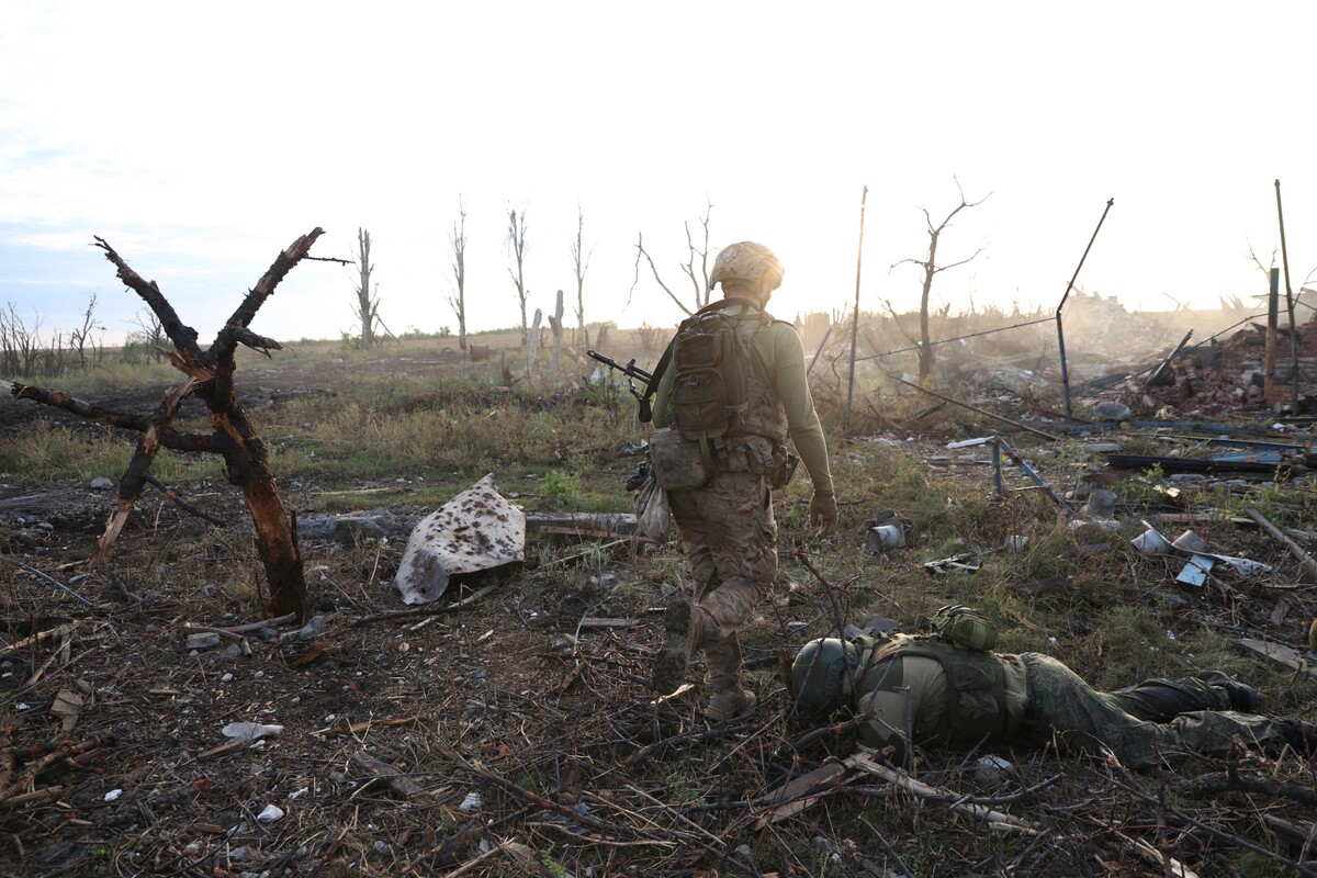 Veliteľ z 3. samostatnej ukrajinskej útočnej brigády kráča okolo mŕveho tela ruského vojaka na frontovej línii v dedine Andrijivka pri meste Bachmut v Doneckej oblasti na východe Ukrajiny.