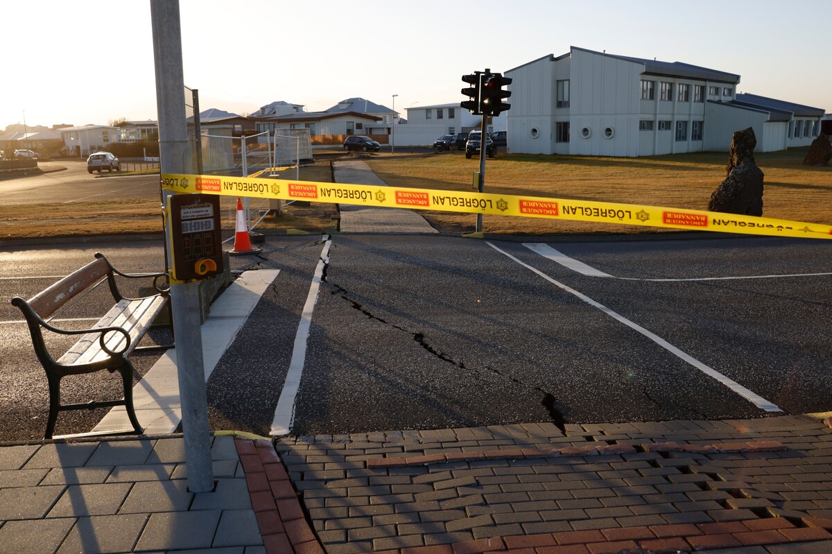 Policejní páska blokuje silnici, na které jsou stopy po seizmické aktivitě v islandském městě Grindavík. 