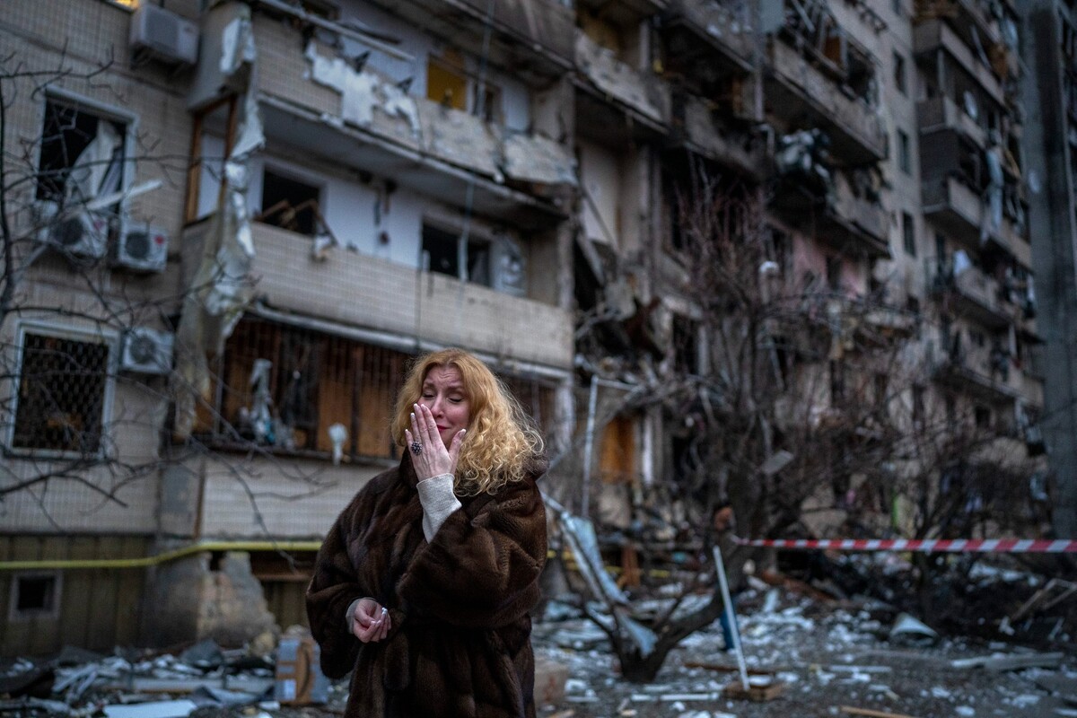 Natali Sevriuková pláče před zničeným panelákem po raketovém útoku ruské armády v ukrajinské metropoli Kyjev v pátek 25. února 2022.