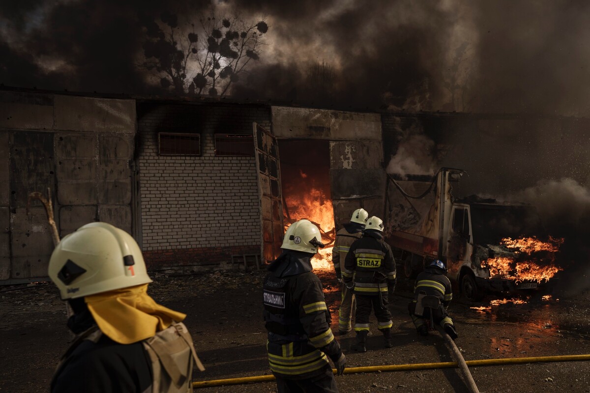 Hasiči počas hasenia požiaru skladu po ruskom bombardovaní 21. apríla 2022 v ukrajinskom Charkove.