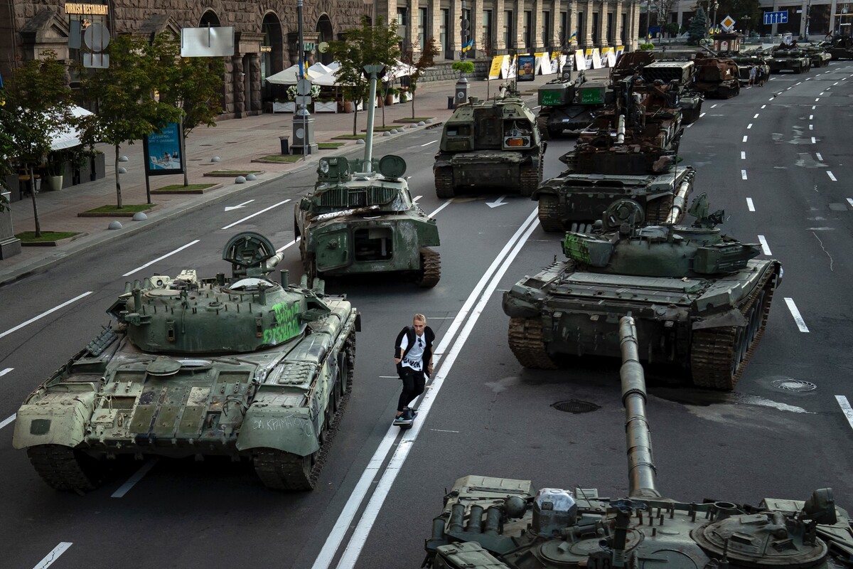 Muž na skejtborde prechádza okolo zničených ruských vojenských vozidiel v centre Kyjeva, kde sú vystavené. Ukrajinci si ich chodia prezerať a fotiť sa s nimi. (24. augusta 2022)