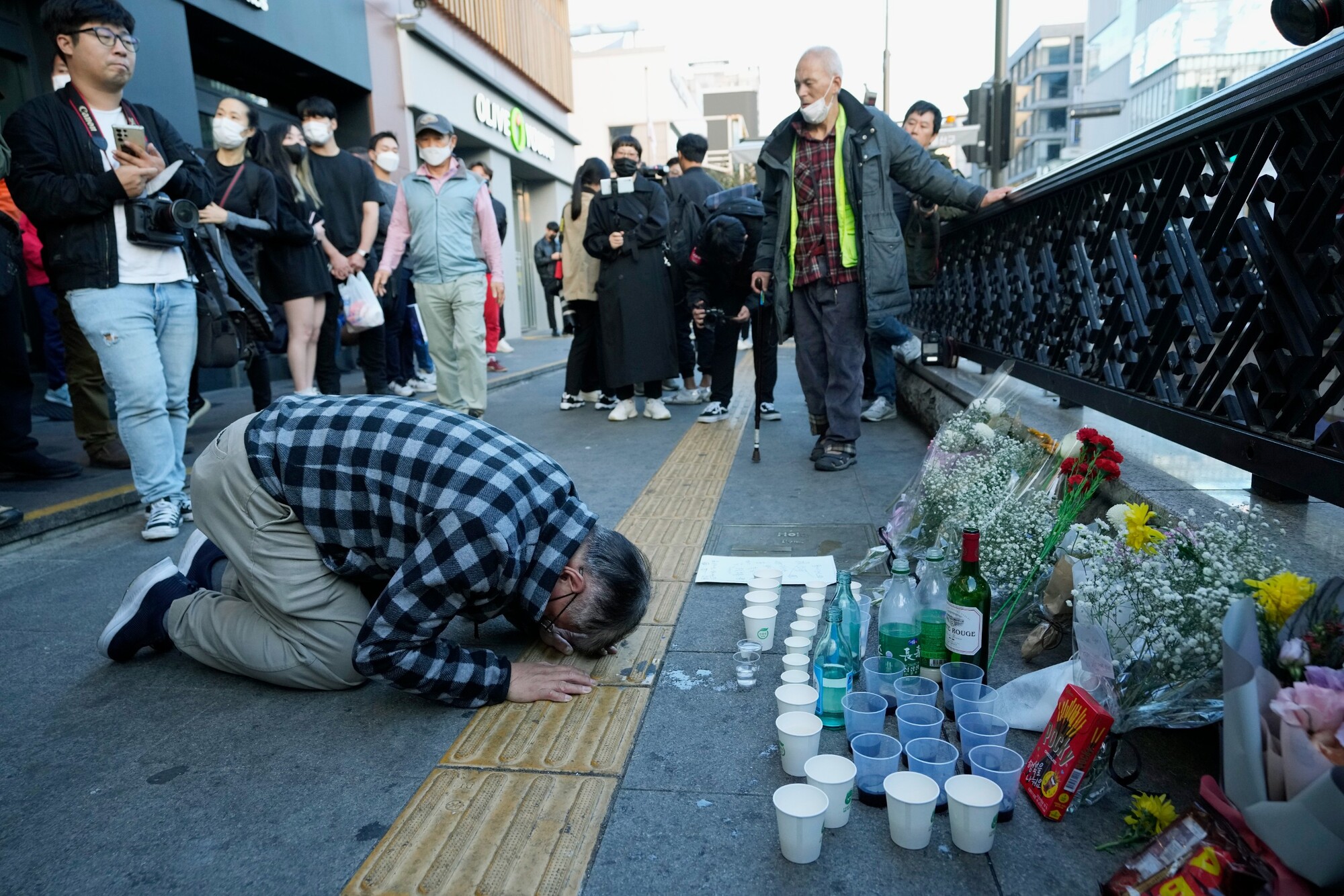 Muž kľačí na pamiatku 151 obetí neďaleko miesta tlačenice, ku ktorej došlo v sobotu počas osláv sviatku Halloween v Soule. (30. októbra 2022)