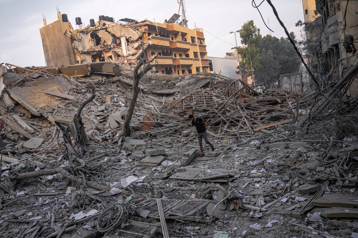 Palestinci zkoumají trosky budovy zasažené izraelským raketovým útokem na Pásmo Gazy.