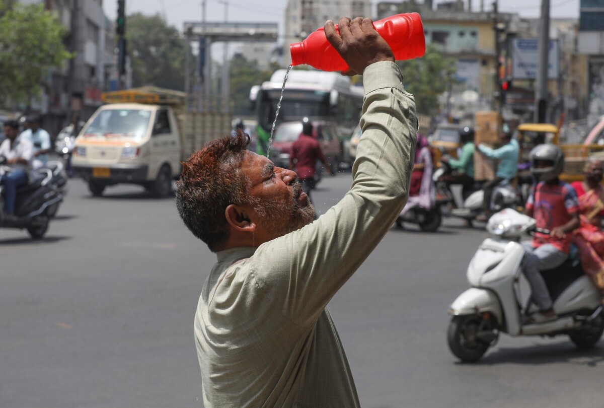 Muž se během vlny veder snaží osvěžit na ulici v indickém Hajdarábádu. Fotka byla pořízena 14. května 2022.