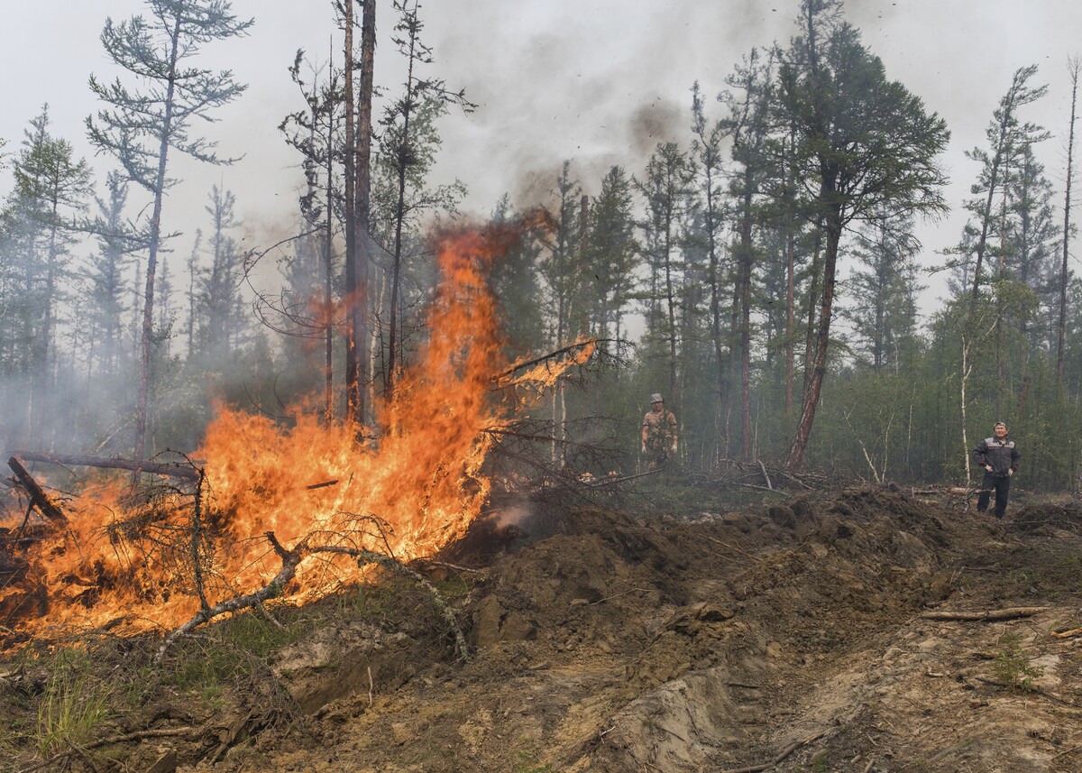 Dobrovoľníci hasia lesný požiar v dedine Magaras v Jakutsku na ruskom Ďalekom východe 18. júla 2021. Lesné požiare vyčíňajúce v Rusku sú čoraz nebezpečnejšie pre ľudí. Úrady v najviac postihnutých oblastiach Sibír a Jakutsko na východe krajiny varovali v nedeľu obyvateľov vo vyše 50 dedinách pred toxickým dymom. 