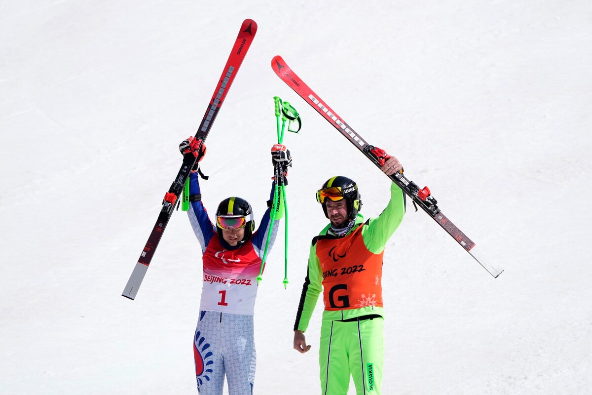 Slovenský reprezentant v paraalpskom lyžovaní Miroslav Haraus (vľavo) a navádzač Maroš Hudík sa tešia zo zisku bronzovej medaily v obrovskom slalome zrakovo znevýhodnených na zimných paralympijských hrách v Pekingu vo štvrtok 10. marca 2022. 